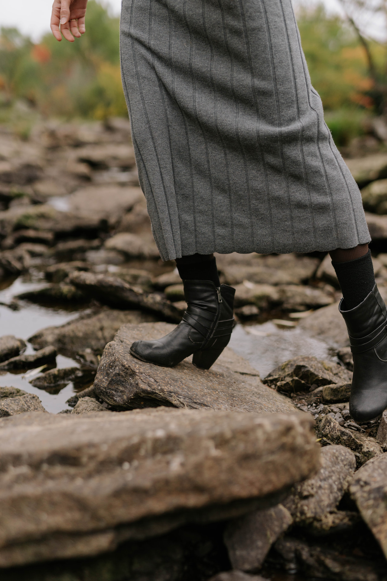Boots stepping carefully across river stones